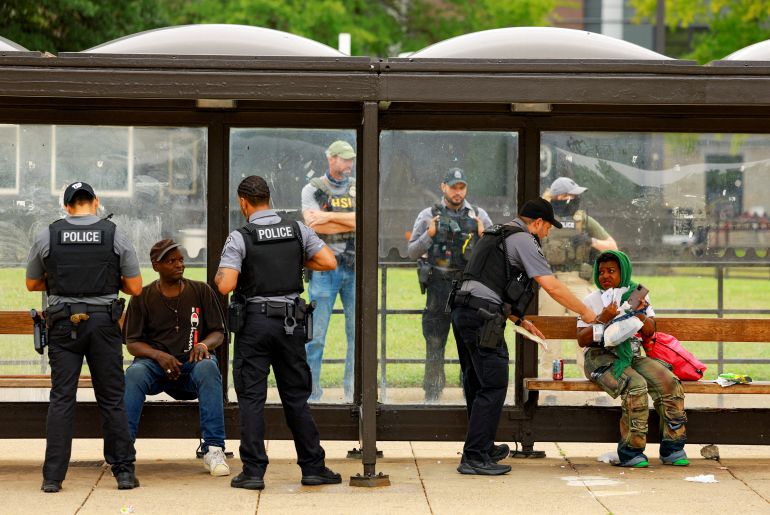 Police officers check individuals at the Anacostia bus station in Washington, D.C., U.S., August 20, 2025. REUTERS/Jose Luis Gonzalez     TPX IMAGES OF THE DAY