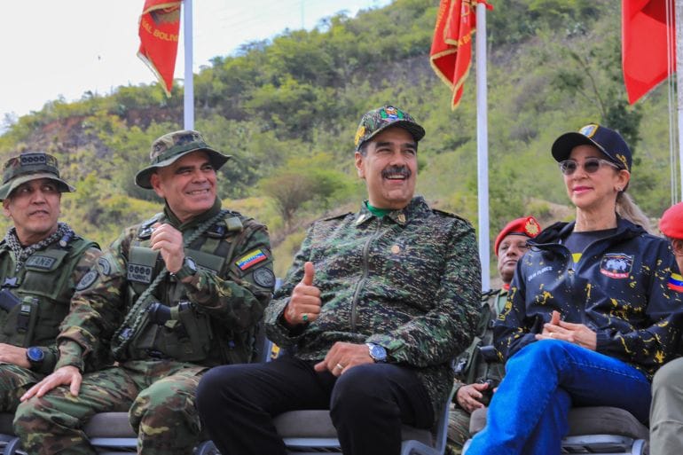 This handout picture released by the Venezuelan Presidency on August 28, 2025, shows Venezuela's President Nicolas Maduro (C-R) giving a thumbs up next to Defense Minister Vladimir Padrino Lopez (C-L) and First Lady Cilia Flores (R) as they watch military exercises at a training camp in Caracas. Venezuela's President Nicolas Maduro said that "there is no way" a foreign force could invade Venezuela on August 28, 2025, amid military operations announced by the United States in the Caribbean, which the leftist leader describes as a "threat" to his country. (Photo by ZURIMAR CAMPOS / Venezuelan Presidency / AFP) / RESTRICTED TO EDITORIAL USE - MANDATORY CREDIT "AFP PHOTO / VENEZUELAN PRESIDENCY / ZURIMAR CAMPOS" - HANDOUT - NO MARKETING NO ADVERTISING CAMPAIGNS - DISTRIBUTED AS A SERVICE TO CLIENTS - AFP CANNOT INDEPENDENTLY VERIFY THE AUTHENTICITY OR LOCATION, DATE, AND CONTENT OF THESE IMAGES. /