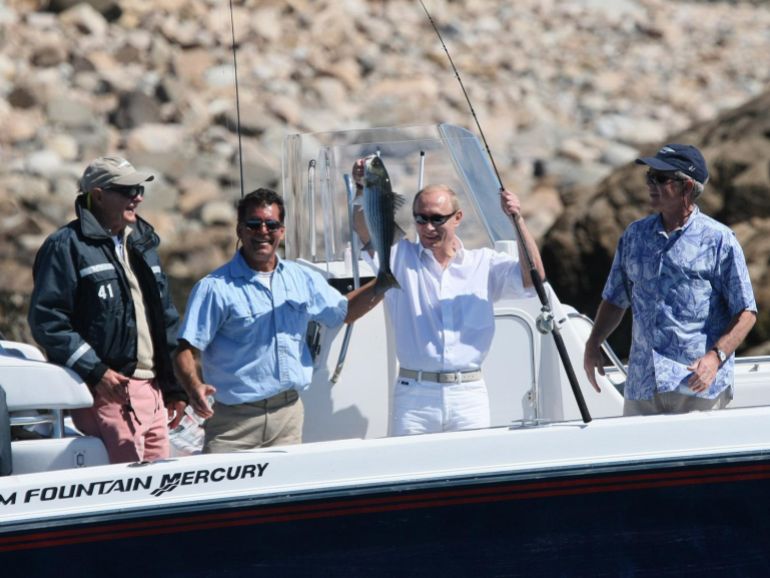 Putin holding up a fish he caught in Maine, while visiting US President George W Bush and his family on July 2, 2007 [FILE: AP Photo]