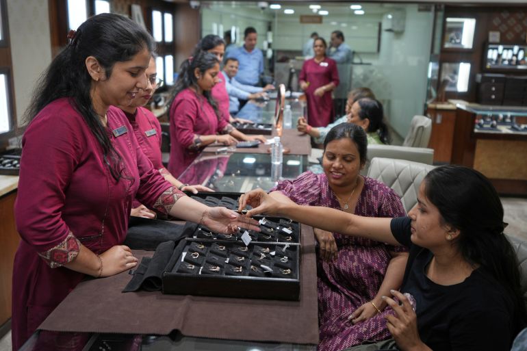 A salesperson shows a diamond ring to a prospective buyer at a jewelry shop in Ahmedabad, India, on April 14, 2025. (AP Photo/Ajit Solanki)