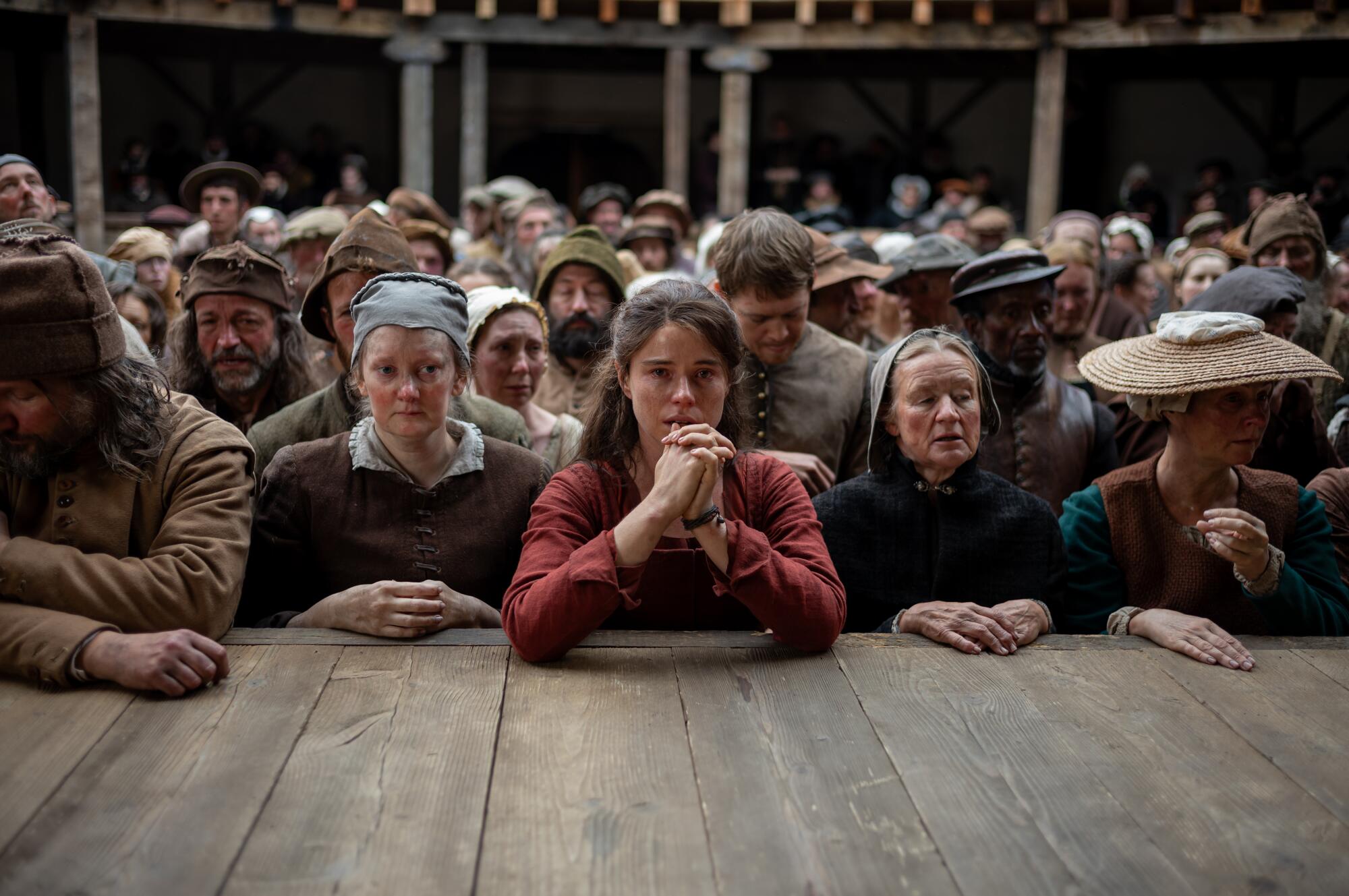 A crowd watches the performance of a play and is moved.