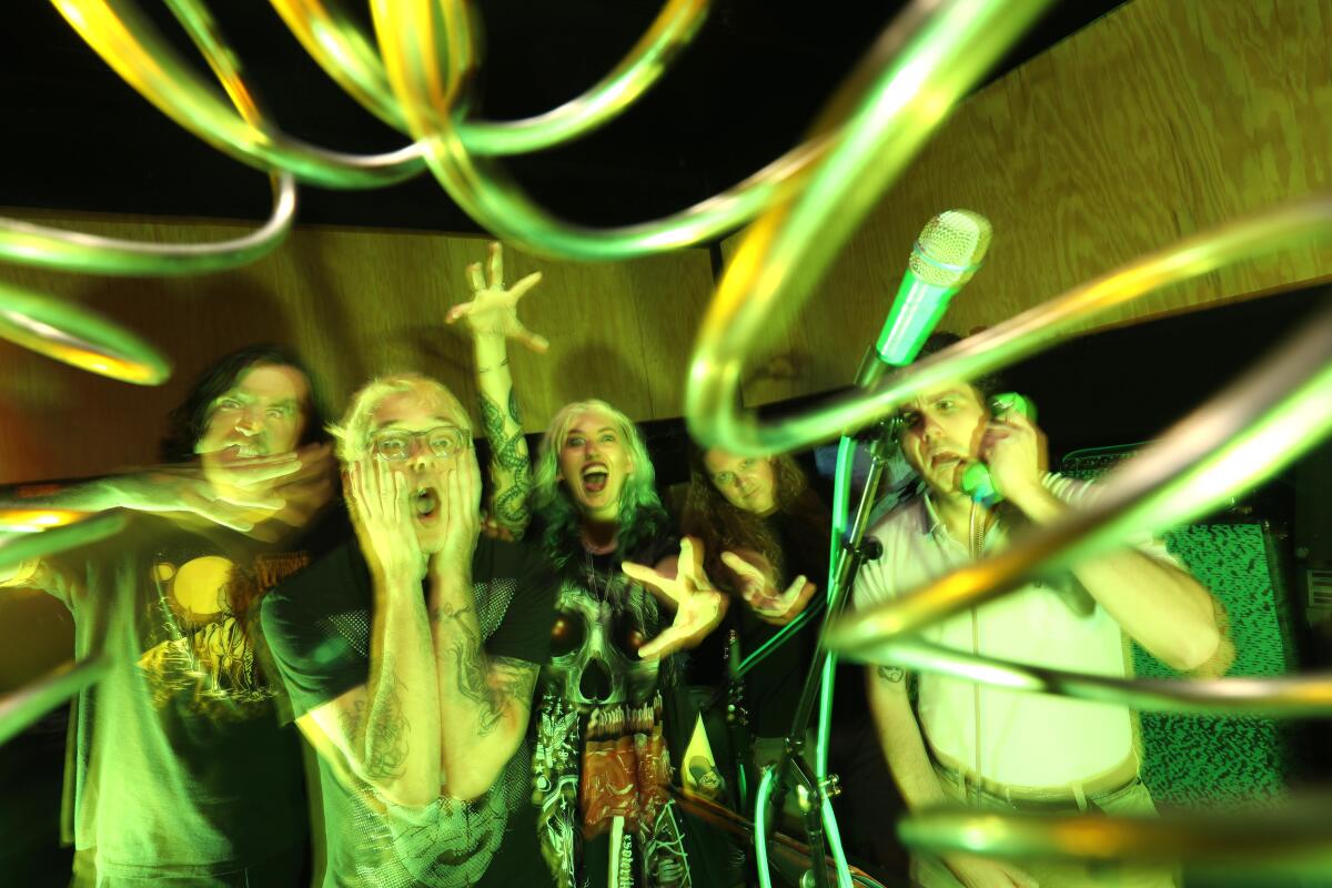 A band doing a freakout pose against a psychedelic backdrop