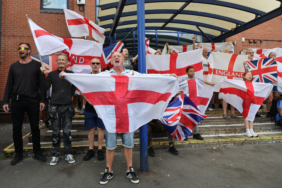 Group of people holding English flags.
