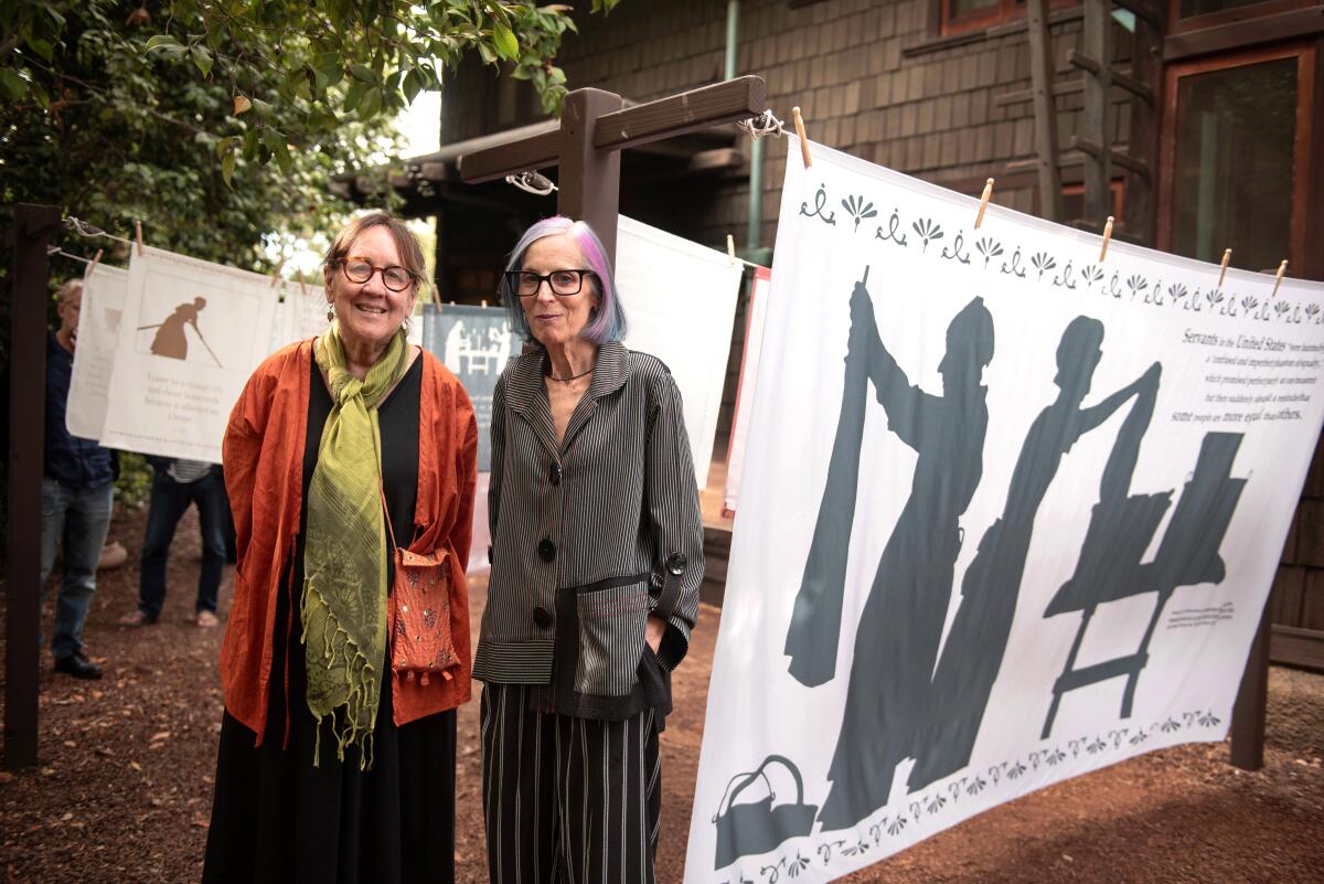 Artists Karen Schwenkmeyer and Lisa Mann stand with their installation "Dirty Laundry" at the Gamble House in Pasadena.