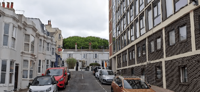 Street scene with parked cars and buildings.