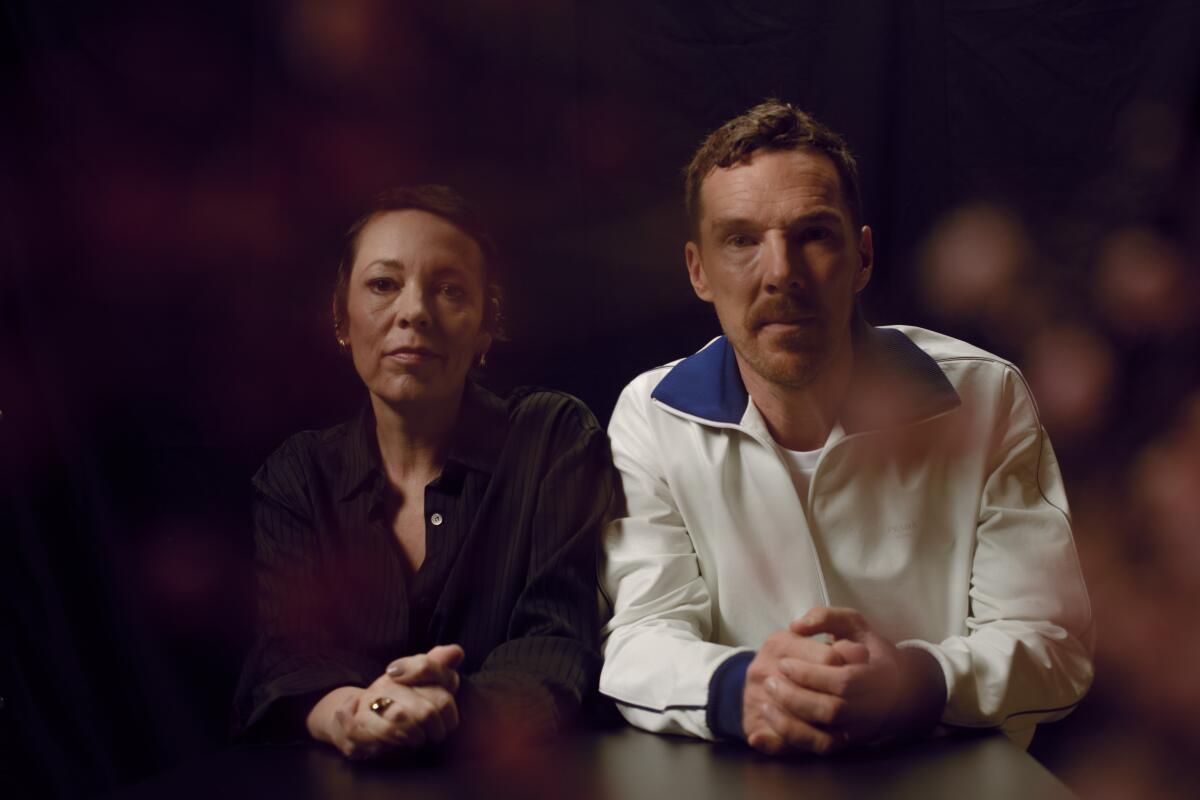 Two actors stare into the lens, a sprinkling of rose petals cascade down