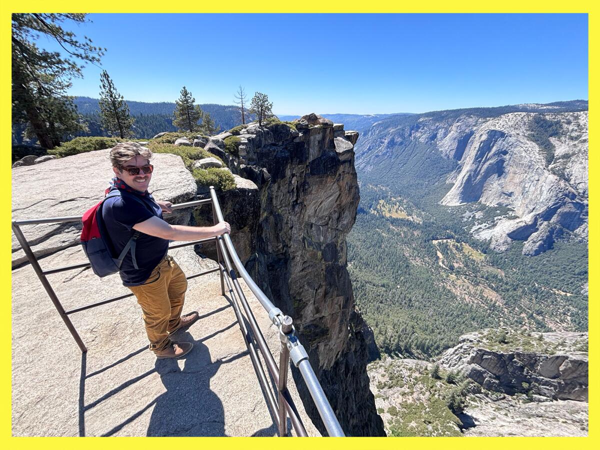 A person stands at the railing in the Taft Point area of Yosemite National Park.