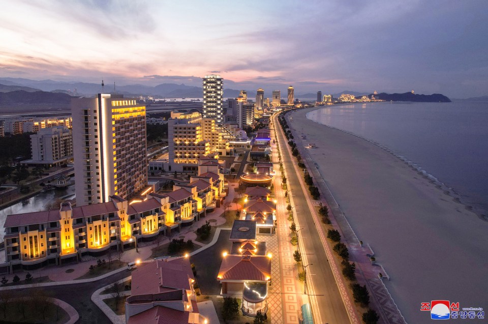 Aerial view of Wonsan city at night, showing hotels and resorts along the coastline.