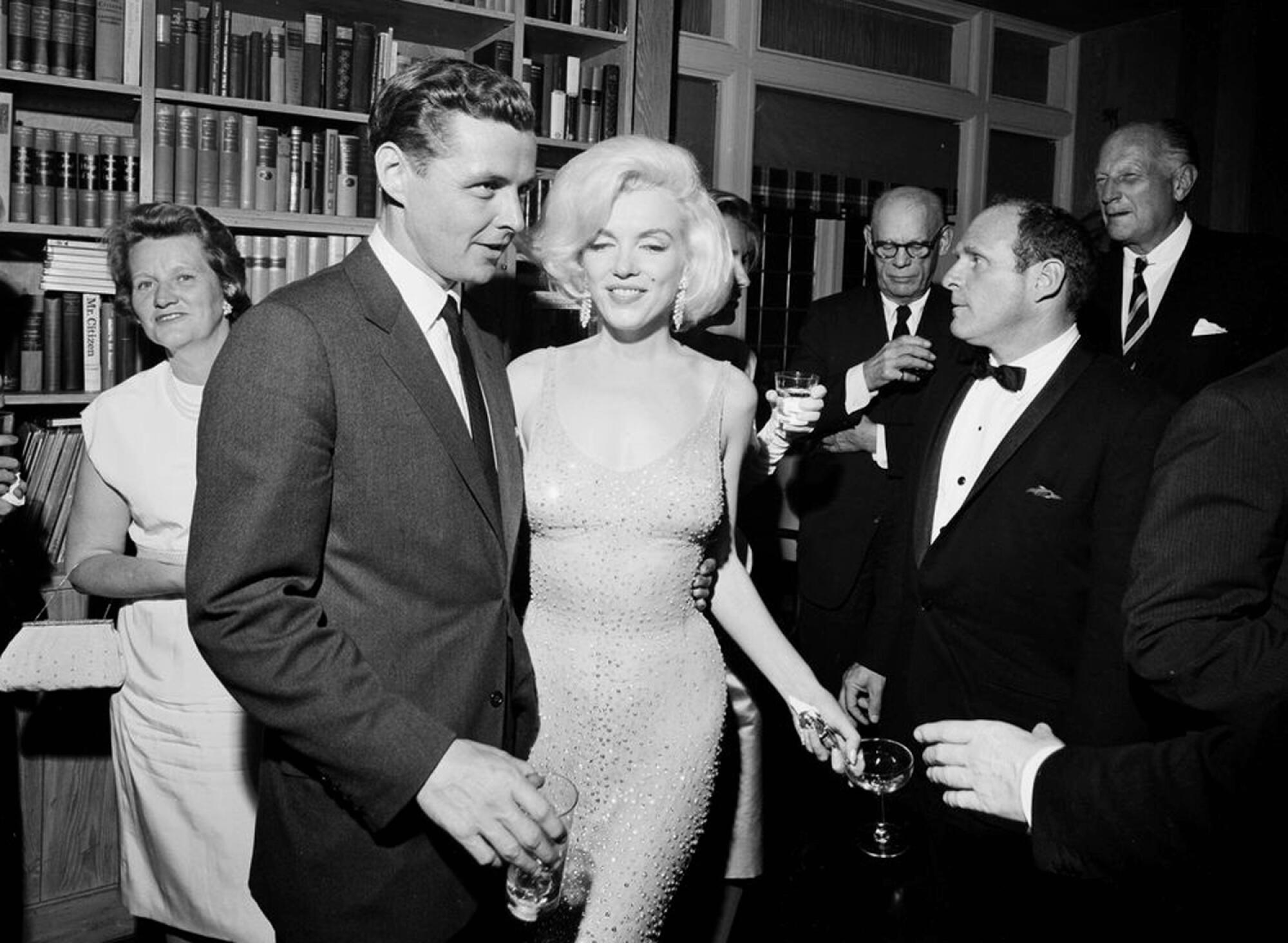 A photograph of Marilyn Monroe surrounded by several people.