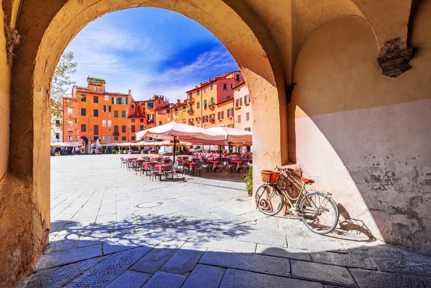  View of Piazza dell'Anfiteatro square through the arch, ancient Roman Empire amphitheater, famous Tuscany.