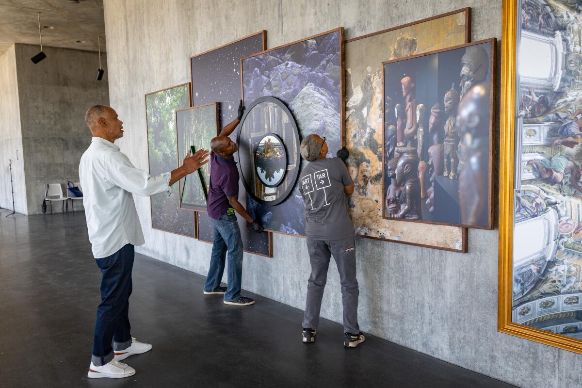 Todd Gray oversees the installation of his photos in a museum.