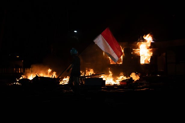 A protester walk in front of Police Office building of Tegalsari Surabaya Sector