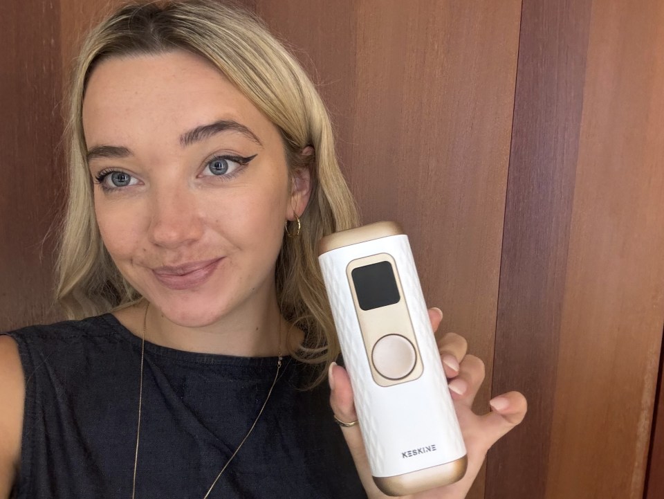 Woman holding a Keskine at-home laser hair removal device.