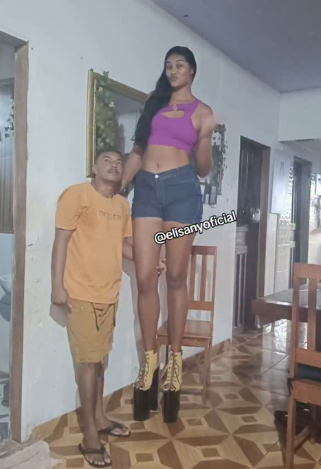 A tall woman standing next to a shorter man.