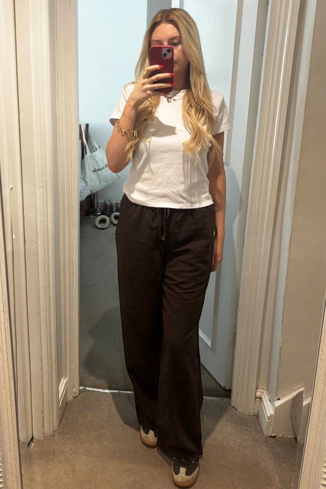 Person wearing brown trousers and a white t-shirt.