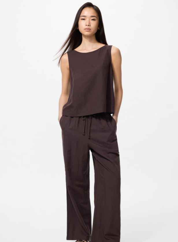 Woman in brown linen top and trousers.