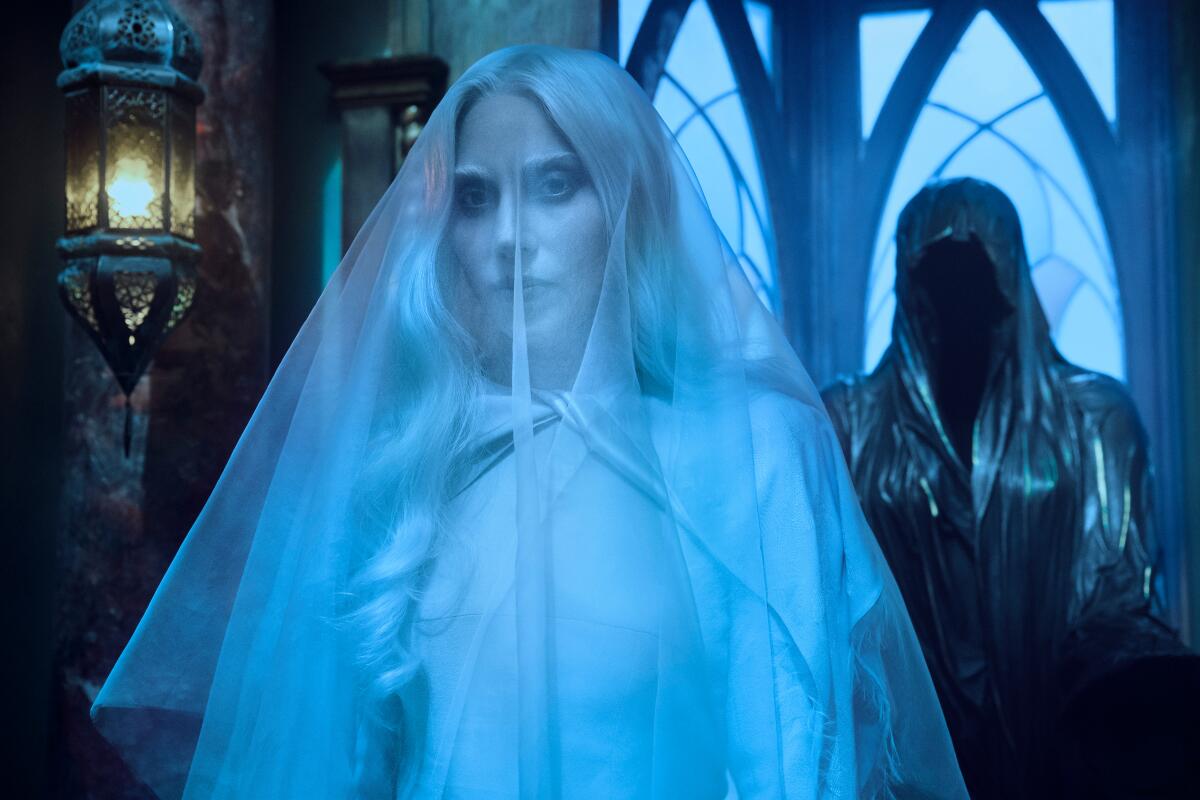 A woman wears a white veil