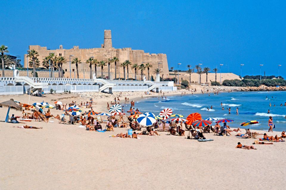 Beach scene in Monastir, Tunisia, with a castle in the background.