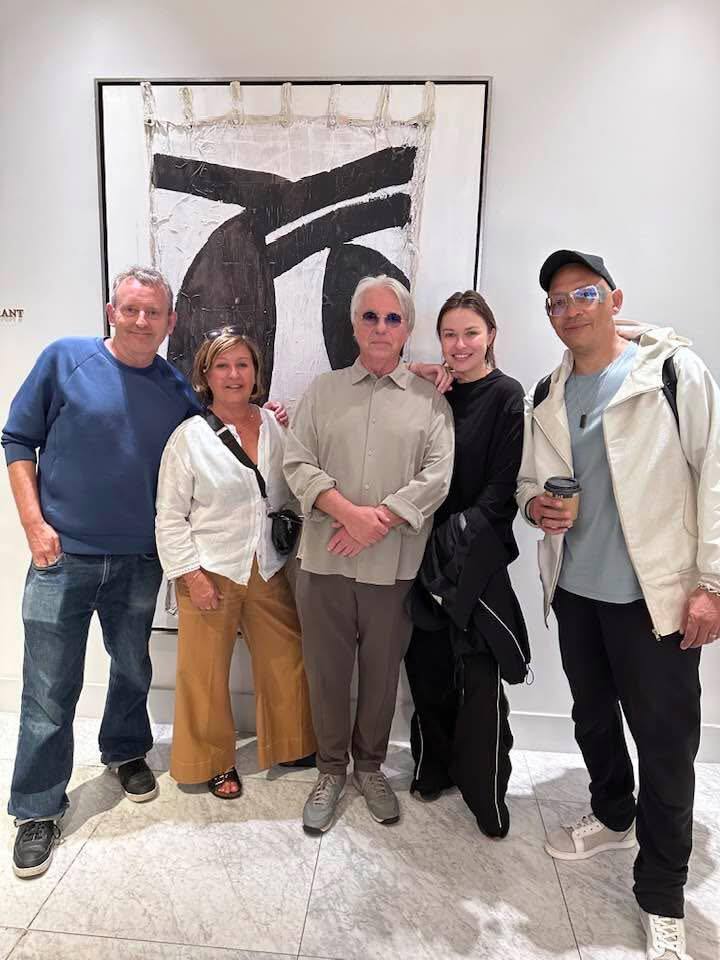 Group photo in front of abstract artwork.