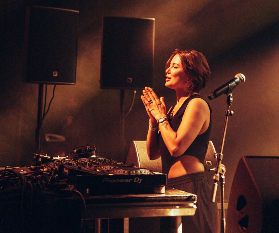 Woman DJ performing on stage.