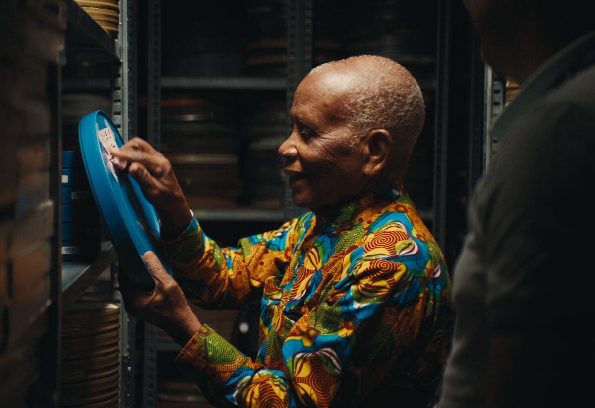 A man inspects a film reel.