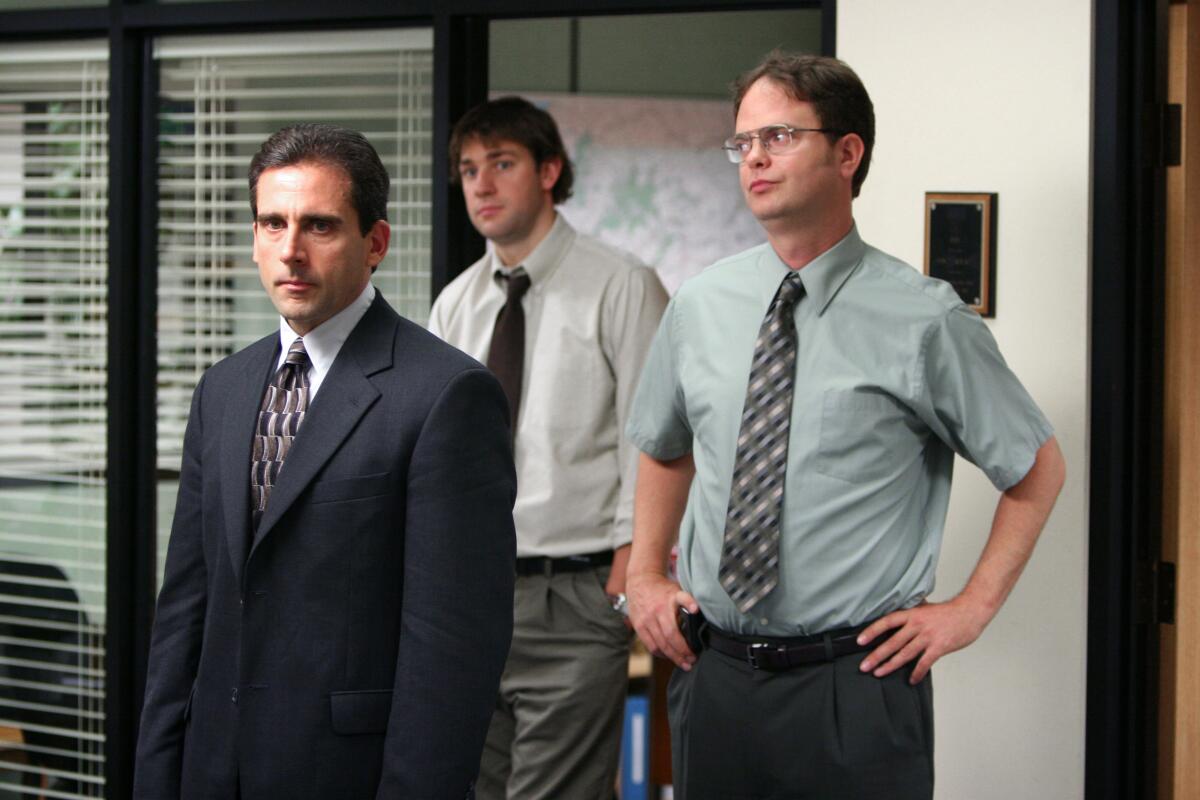 Three men in work attire stand beside each other