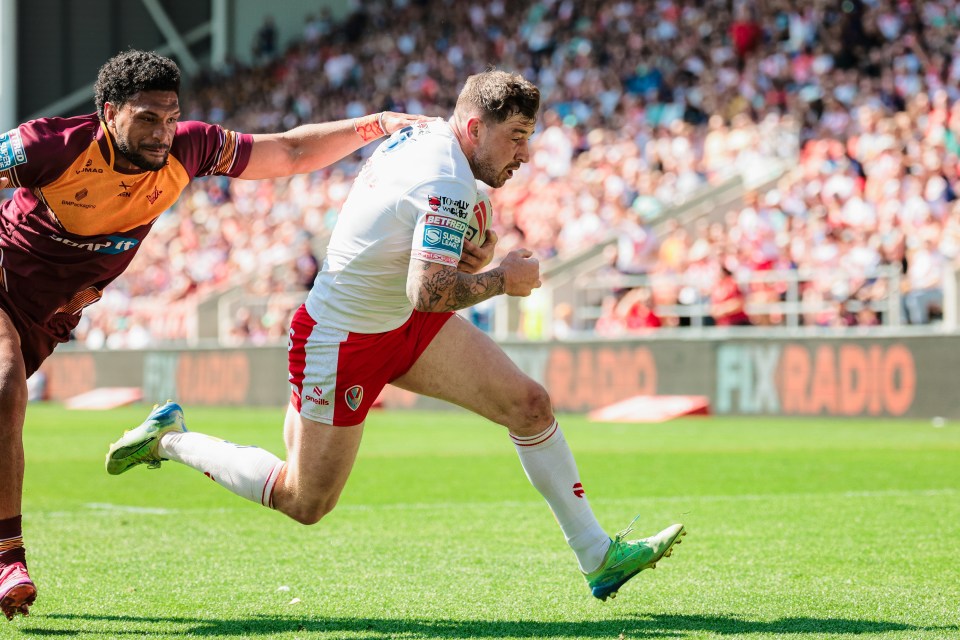 Rugby player running with the ball, being tackled.
