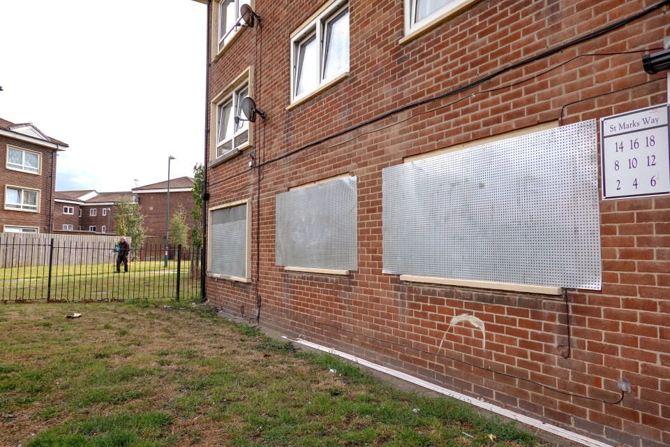 Brick building with boarded-up windows.