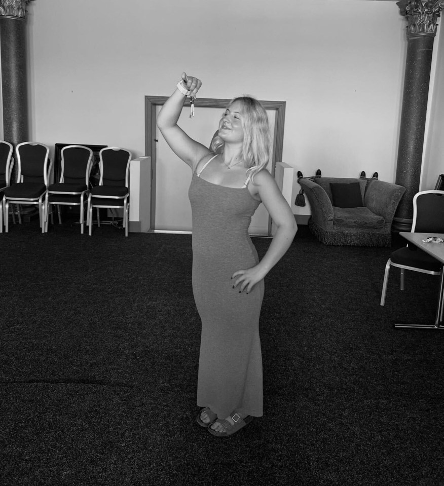 Black and white photo of Daisy Campbell holding up keys.