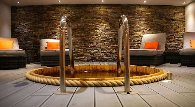 Indoor hot tub with lounge chairs.