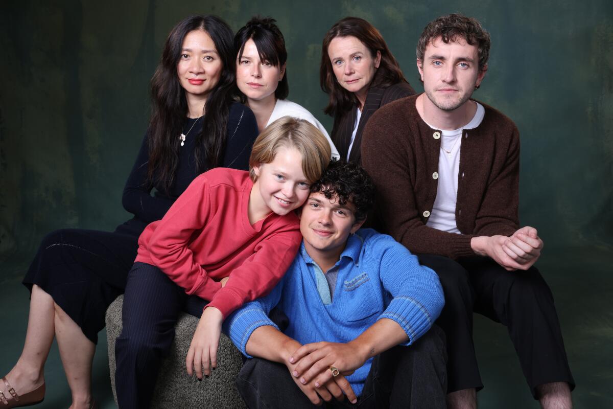 A group of actors and their director pose in a studio.