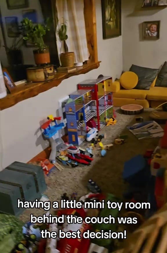 Toys arranged behind a couch in a living room.