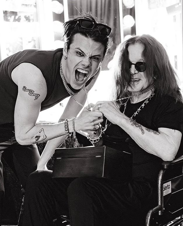 Black and white photo of Ozzy Osbourne receiving a gift.