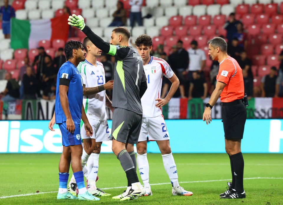 Soccer players and a referee on the field.