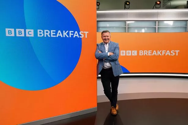 Richard Frediani leaning on BBC Breakfast studio wall