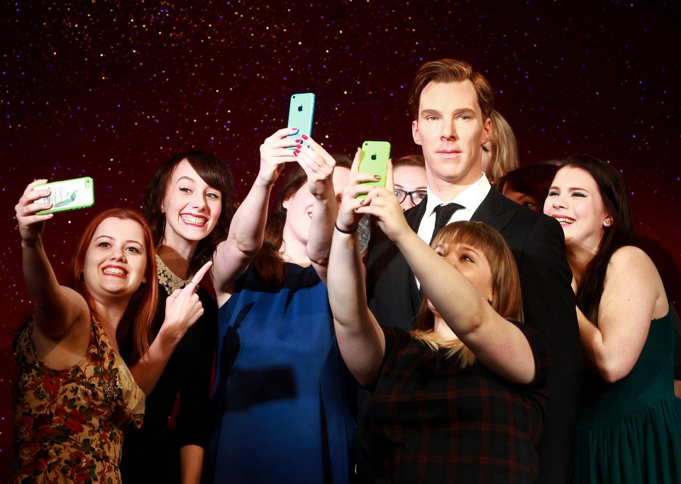 Fans taking selfies with a Benedict Cumberbatch wax figure at Madame Tussauds.