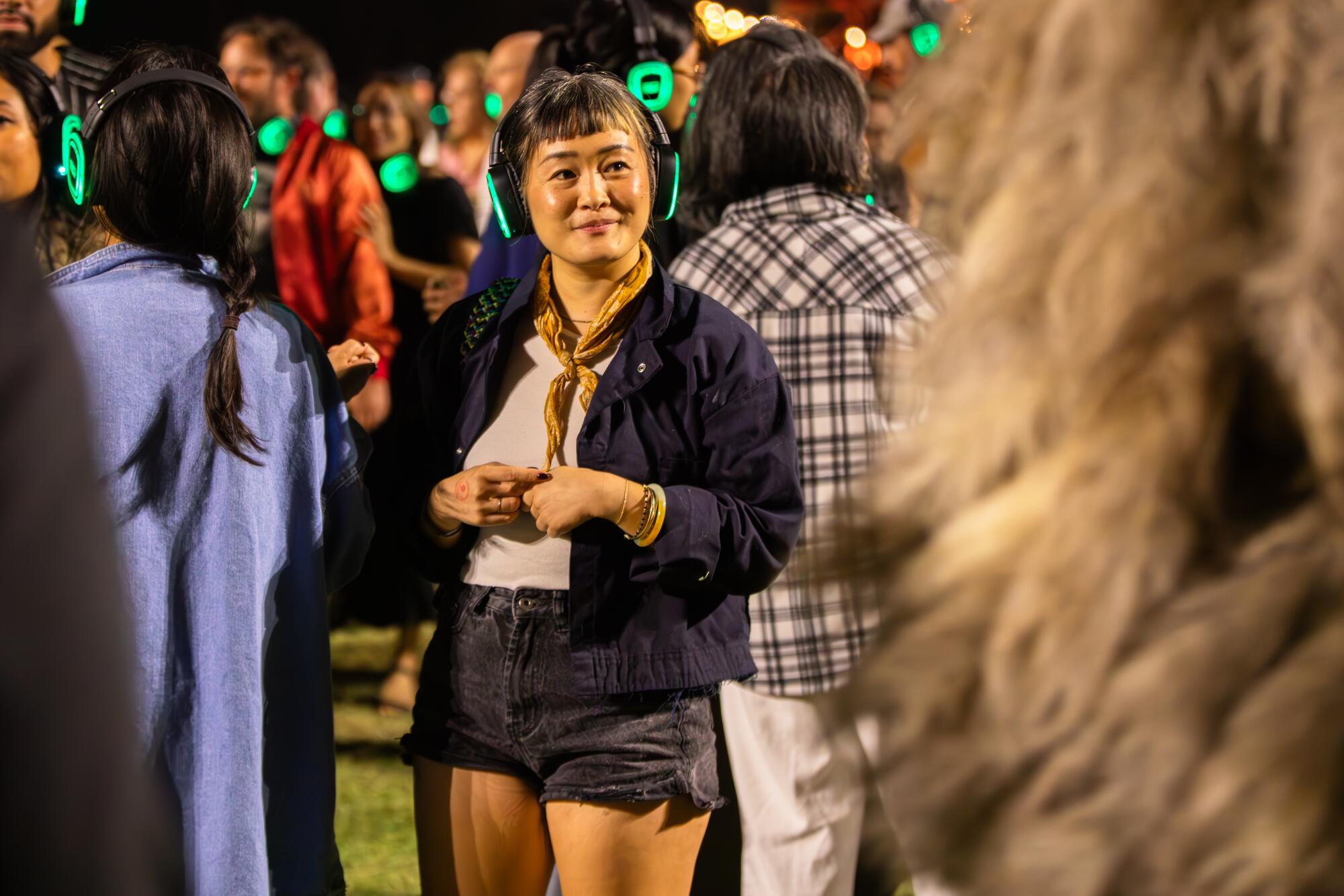 Audiences wearing glowing headphones. 