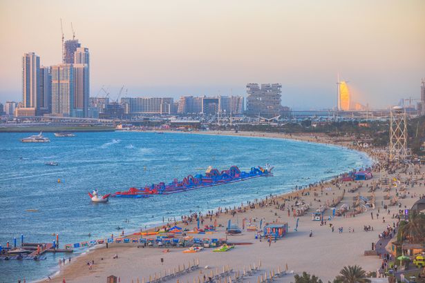 Sunset view of JBR beach next to Palm Jumeirah with Burj Al Arab in background