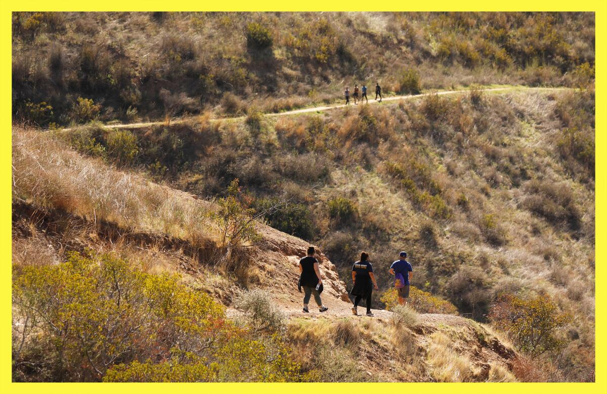 Hikers walk along the upper portions of the Rising Sun Trail in Solstice Canyon park.