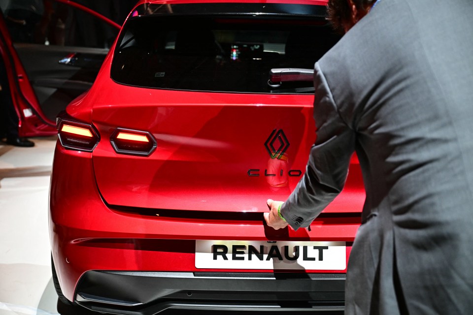 Rear view of a red Renault Clio at a car show.