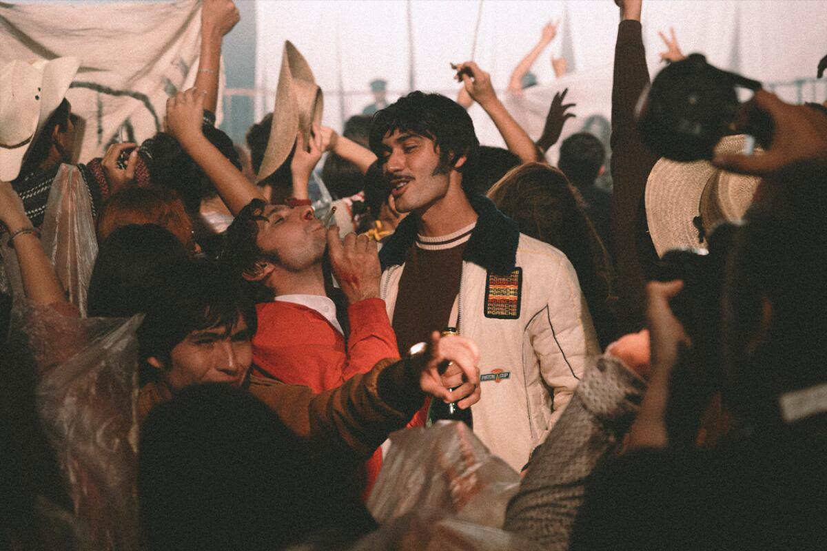 A movie still of a young man in a crowd of revelers.