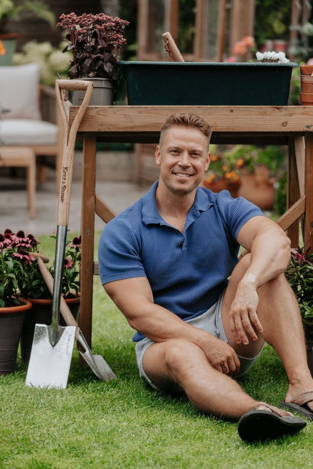 A man sitting on the grass in a garden.