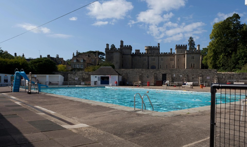 Outdoor swimming pool with castle in the background.