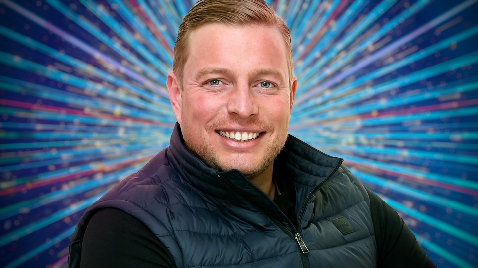 Portrait of a man smiling in front of a sparkly background.