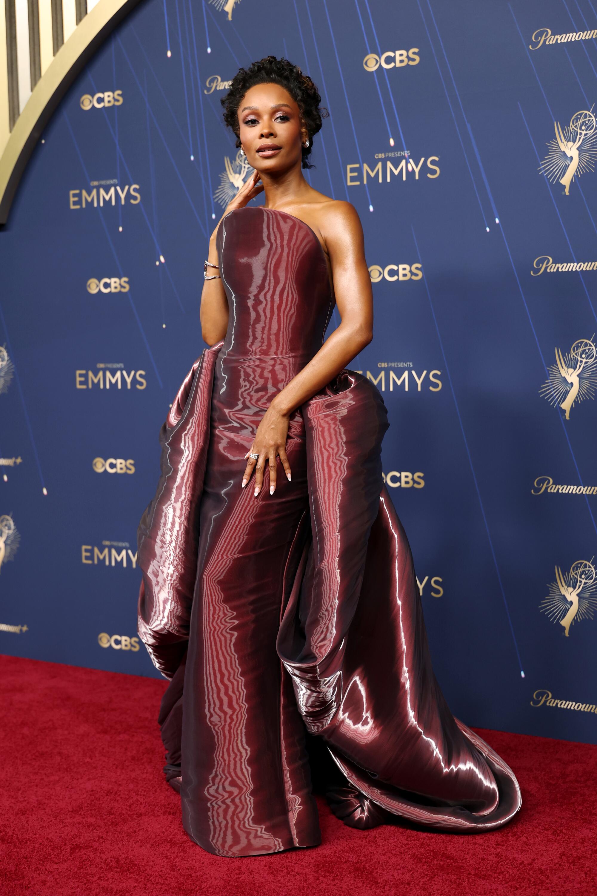 Zuri Hall wears a metallic burgundy dress.