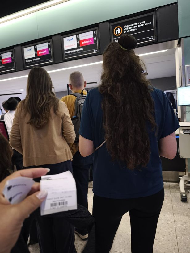 Bianca Perry holding the familys luggage tags while queuing at baggage enquiries in the airport.