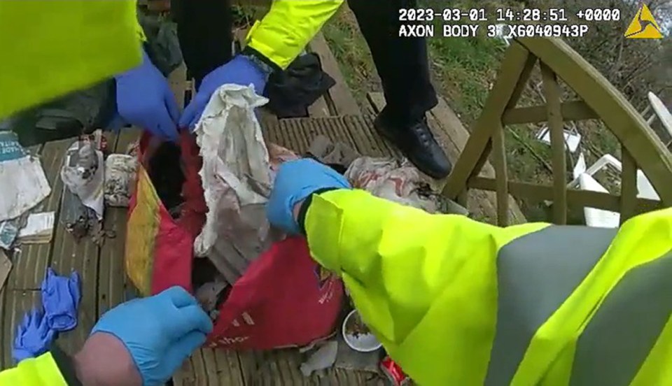 Police officers discovering a baby's body in a bag.