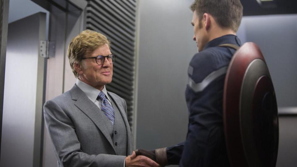 Robert Redford shaking hands with Captain America.