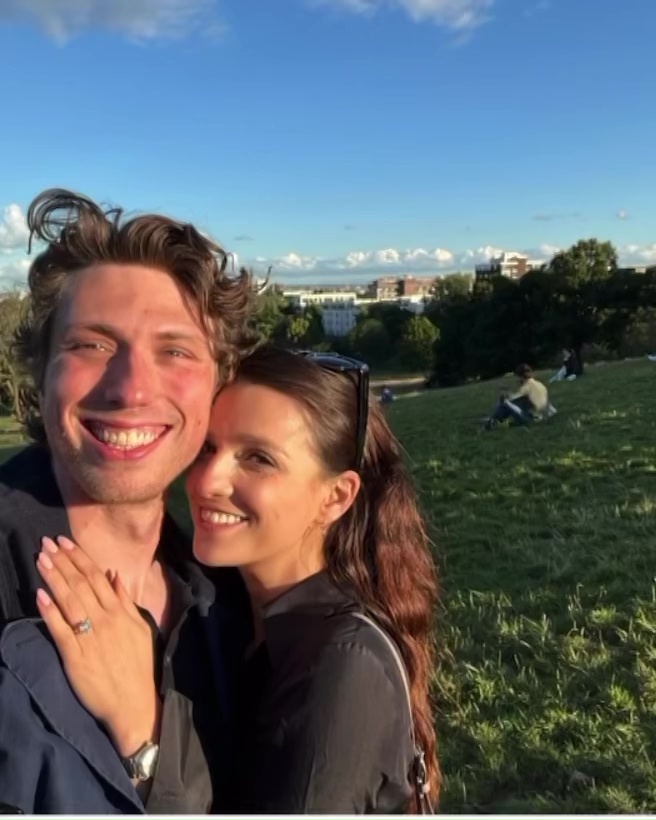 Marisa Abela and Jamie Bogyo smiling for a selfie, Abela showing off her engagement ring.