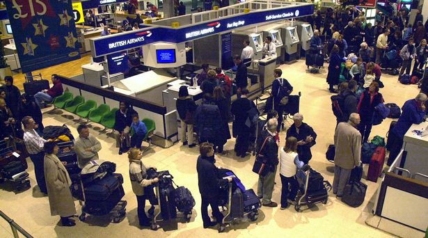 passengers  queueing up at the Check-In desks at Heathrow Airport 's Terminal 1,